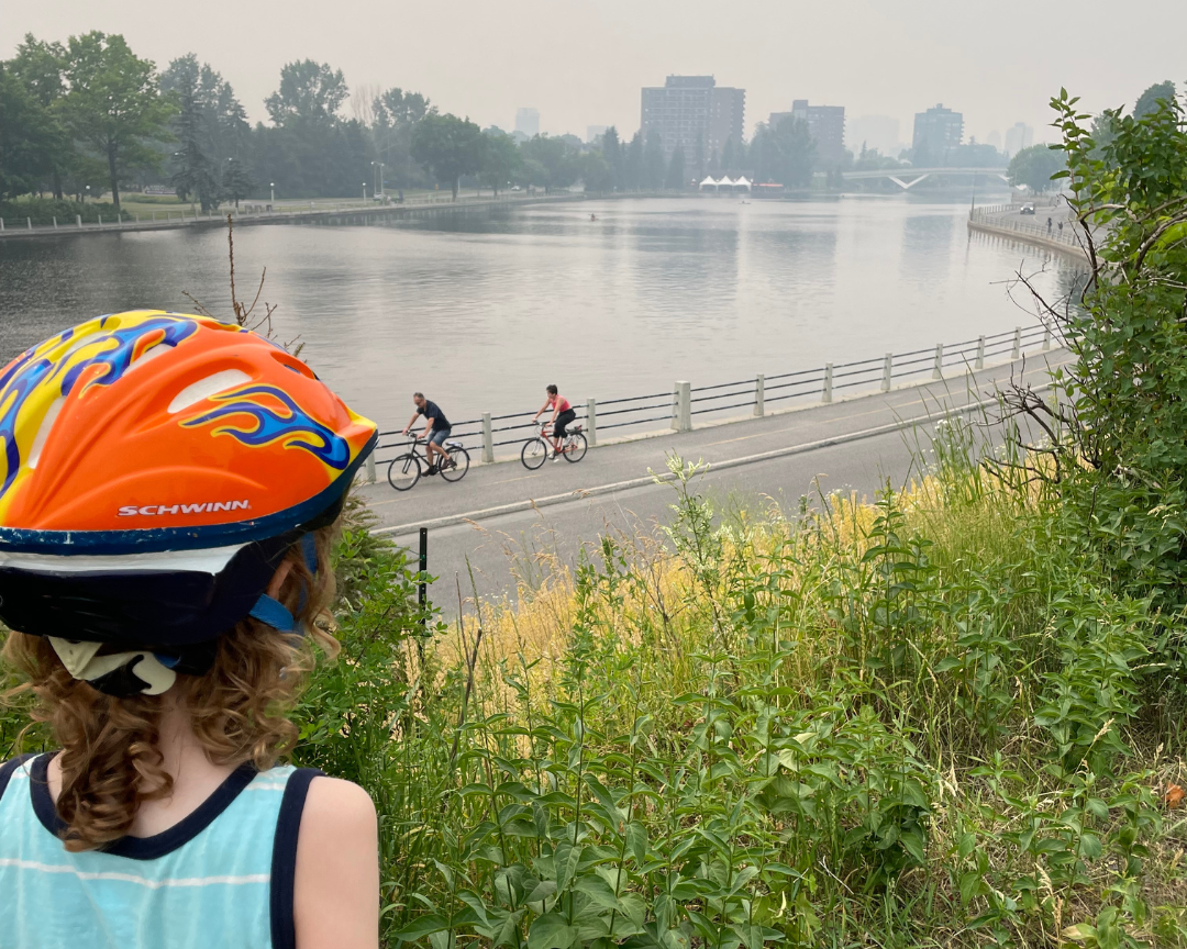 Image of Robb’s son, William, gazing into a smoke-filled sky overlooking the Ottawa River while cyclists pass below
