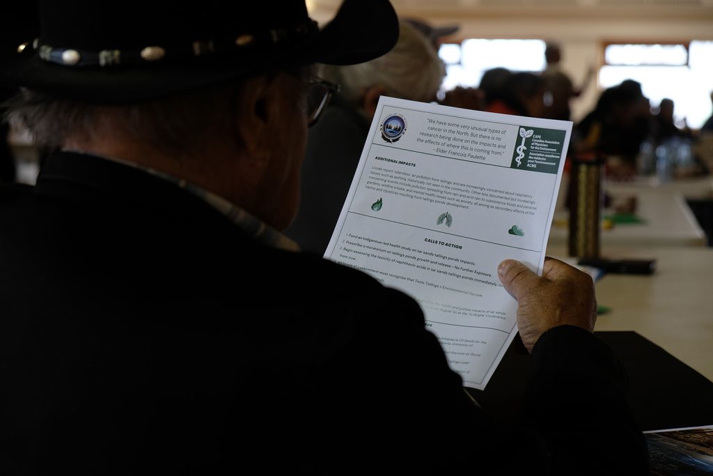 A participant of the sharing circle reads a fact sheet prepared by CAPE