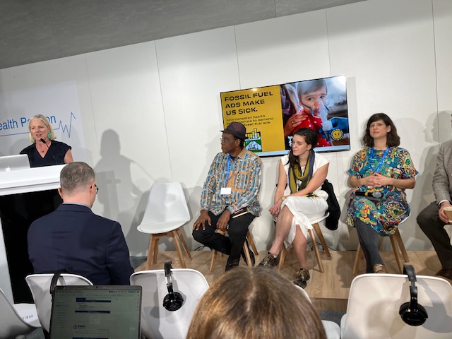 Catherine McKenna, former Canadian federal Minister of the Environment, talks on a podium at a CAPE-led panel, talking about the "Fossil Fuel Ads Make Us Sick" campaign