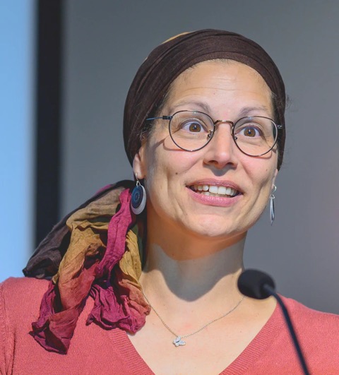 Headshot of Dr. Lyndia Dernis behind a microphone
