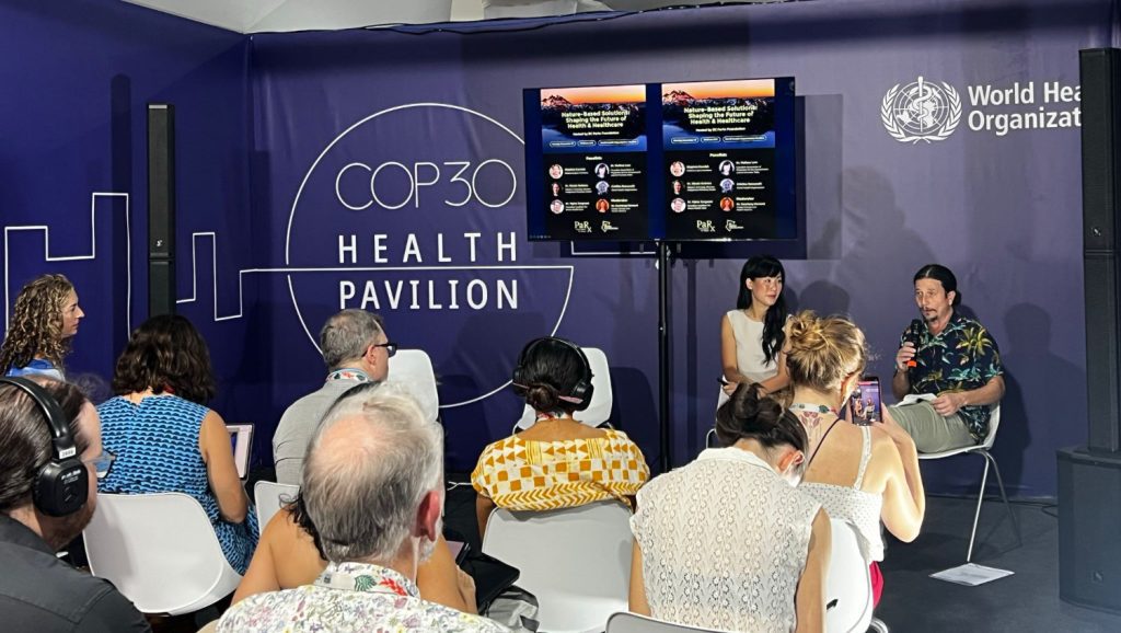 Melissa Lem speaking in front of an audience at COP30 Health Pavilion