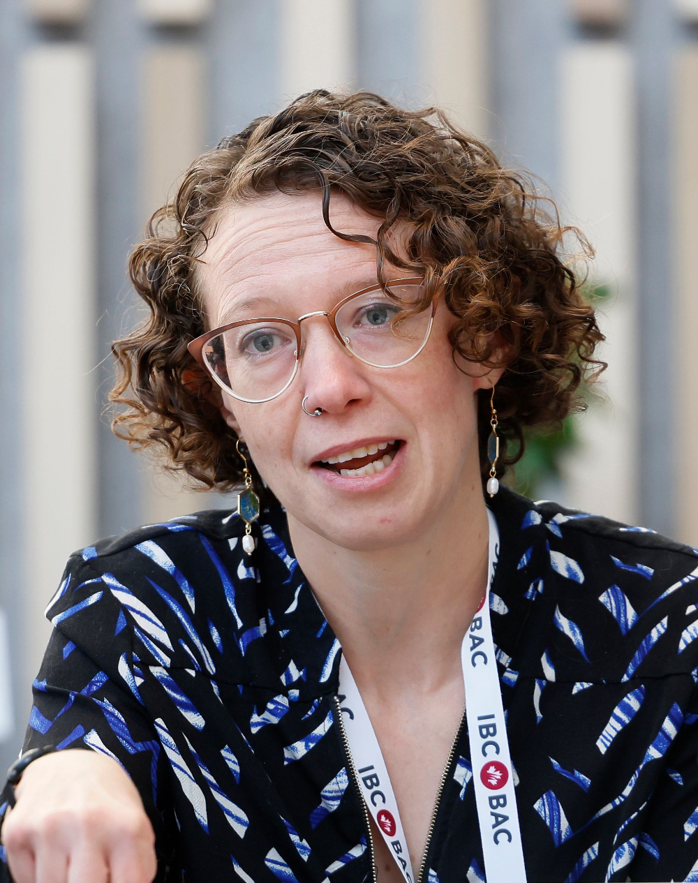 Image de profil de Sabrina Bowman parlant, portant des lunettes et un chemisier bleu